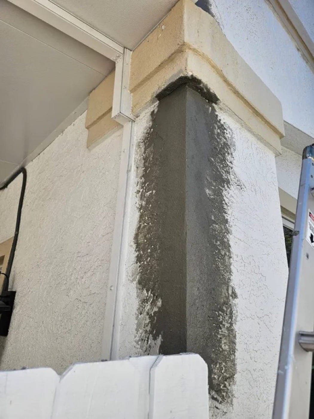 Repaired and retextured stucco band under window